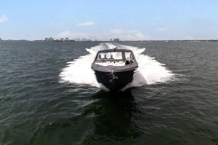 Slide: The Image of 2023 Cruisers 42 GLS OB boat cruising on open water, city skyline in background. - 7