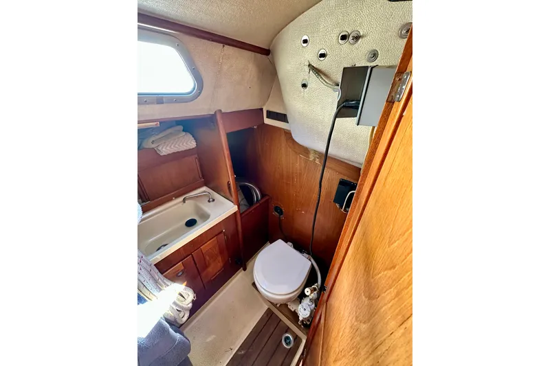 Slide: The Image of Compact bathroom in 1983 Sirena 38 yacht with sink, toilet, and wooden cabinetry. - 10