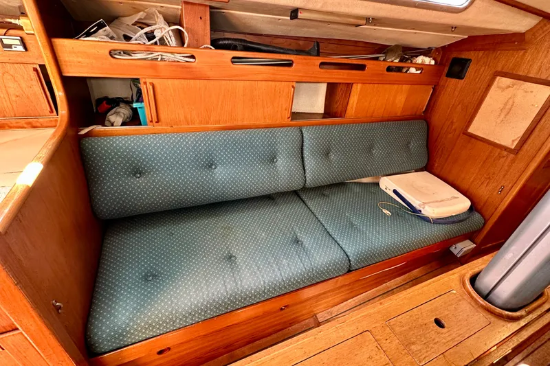 Slide: The Image of Interior of 1983 Sirena 38 sailboat with blue cushioned seating and wooden cabinetry. - 12