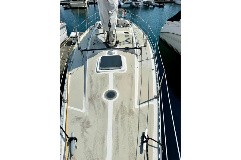 Slide: The Image of 1983 Sirena 38 sailboat deck view at marina, showcasing clean lines and rigging. - 27