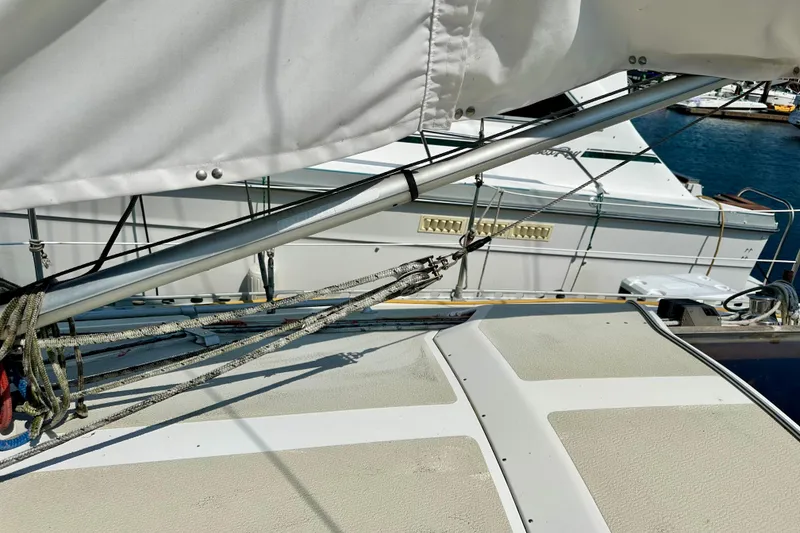 Slide: The Image of Sailboat deck view of 1983 Sirena 38, featuring rigging and marina background. - 29