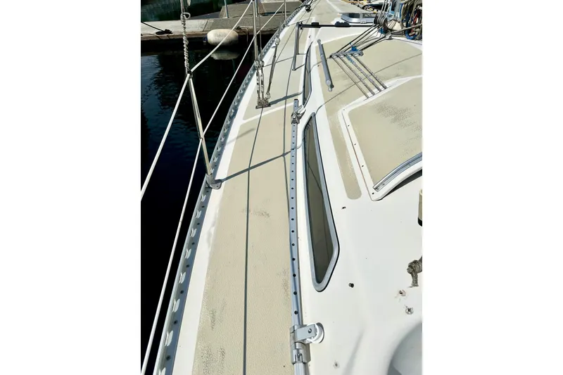Slide: The Image of 1983 Sirena 38 sailboat deck with rigging and windows, docked at marina. - 38