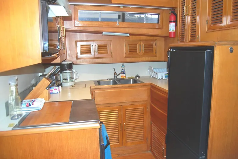Slide: The Image of Galley with Stove, Oven, Fridge/Freezer, Microwave, sink and storage. - 13