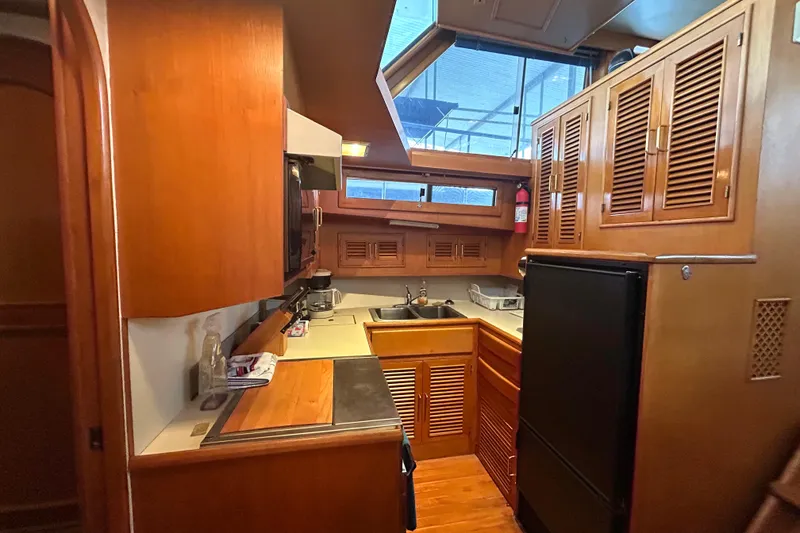 Slide: The Image of 1988 CHB Ponderosa Motor Yacht kitchen with wooden cabinets and modern appliances. - 14