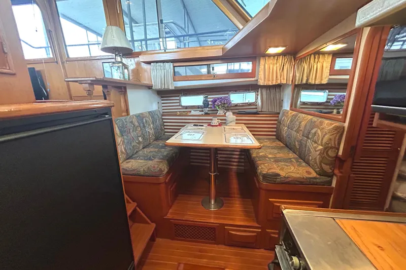 Slide: The Image of Interior of 1988 CHB Ponderosa Motor Yacht with cozy dining area and wooden finishes. - 16