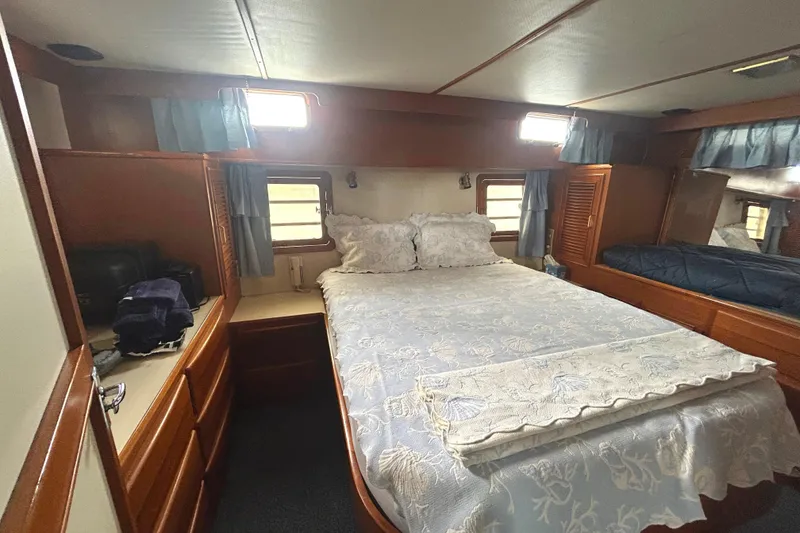 Slide: The Image of 1988 CHB Ponderosa Motor Yacht bedroom with cozy bed, wooden cabinetry, and natural light. - 19