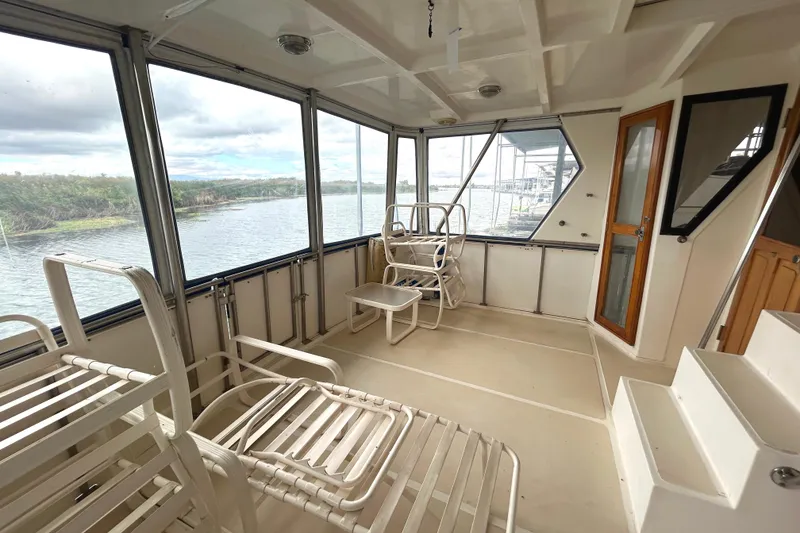 Slide: The Image of 1988 CHB Ponderosa Motor Yacht interior with chairs, windows, and water view. - 24