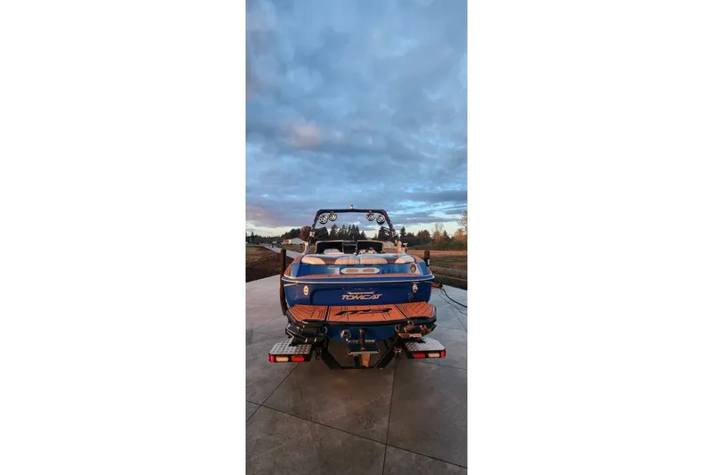 Slide: The Image of 2017 MB F21 boat with blue and orange design, parked on concrete under a cloudy sky. - 8