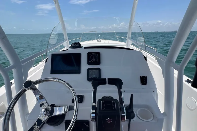 Slide: The Image of 2024 Yamane Center Consoles boat dashboard with steering wheel and navigation screens. - 12