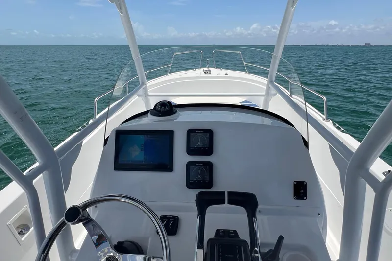 Slide: The Image of 2024 Yamane Center Consoles boat dashboard with navigation screens on open water. - 13
