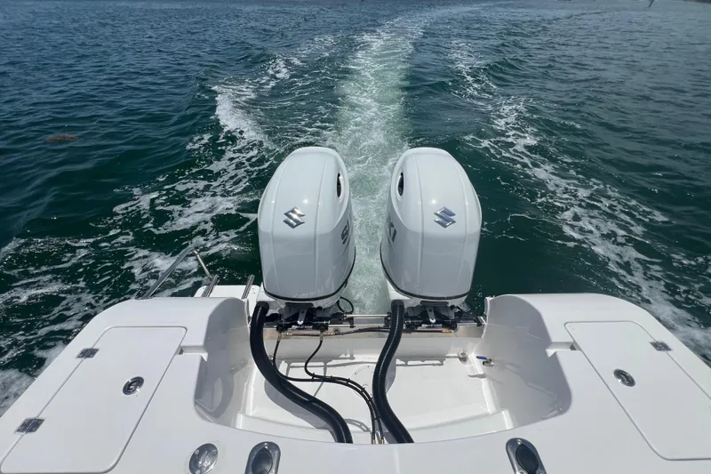 Slide: The Image of 2024 Yamane Center Consoles boat with dual outboard motors on open water. - 14