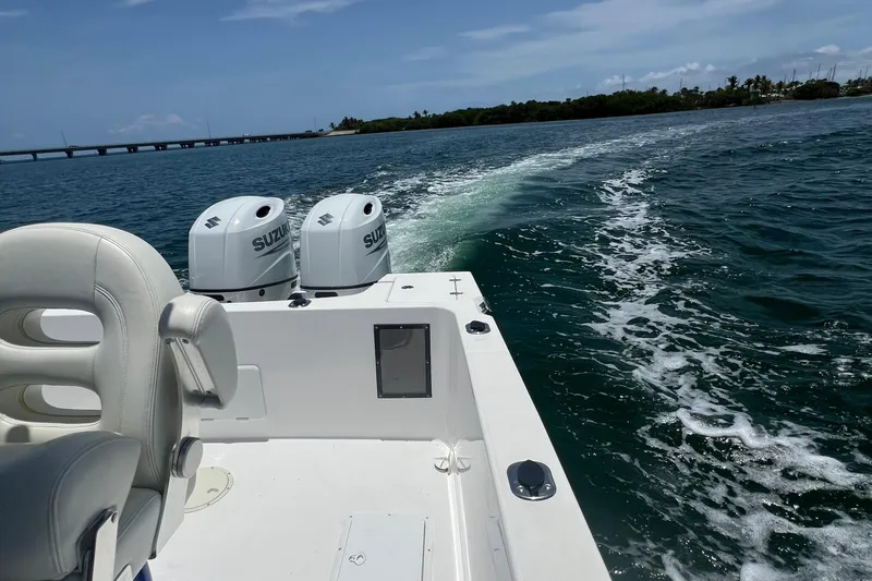 Slide: The Image of 2024 Yamane Center Consoles boat cruising on open water with dual Suzuki engines. - 15