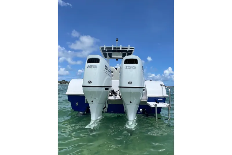 Slide: The Image of 2024 Yamane Center Consoles boat with dual Suzuki 150 outboard engines on clear water. - 3