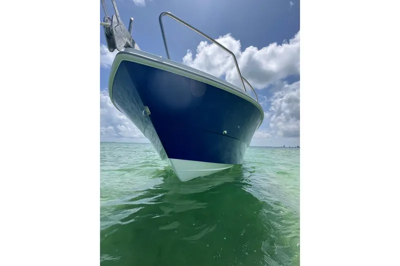 Slide: The Image of 2024 Yamane Center Consoles boat on clear turquoise water under a blue sky. - 4