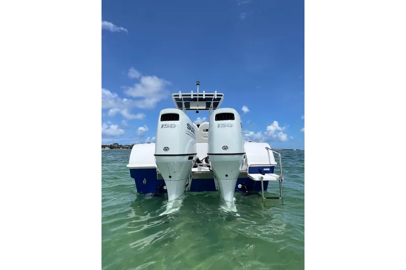 Slide: The Image of 2024 Yamane Center Consoles boat with dual outboard motors on clear water. - 5