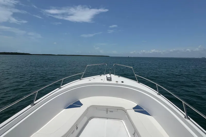 Slide: The Image of 2024 Yamane Center Consoles boat on open water under clear blue sky. - 7