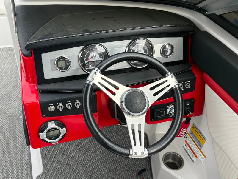 Slide: The Image of Dashboard of a 2013 Four Winns H210 boat with steering wheel. - 14