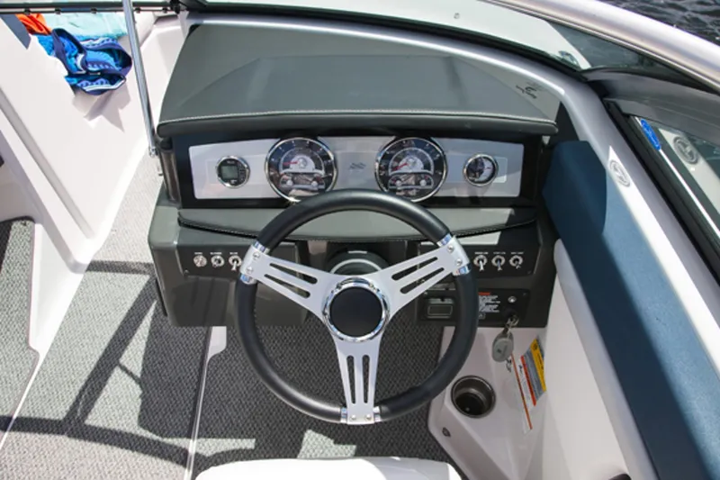 Slide: The Image of 2013 Four Winns H210 boat dashboard with steering wheel and instrument panel. - 2