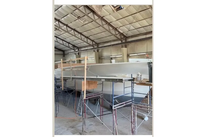 Slide: The Image of 2026 Weaver Sportfish boat under construction in a workshop with scaffolding. - 3