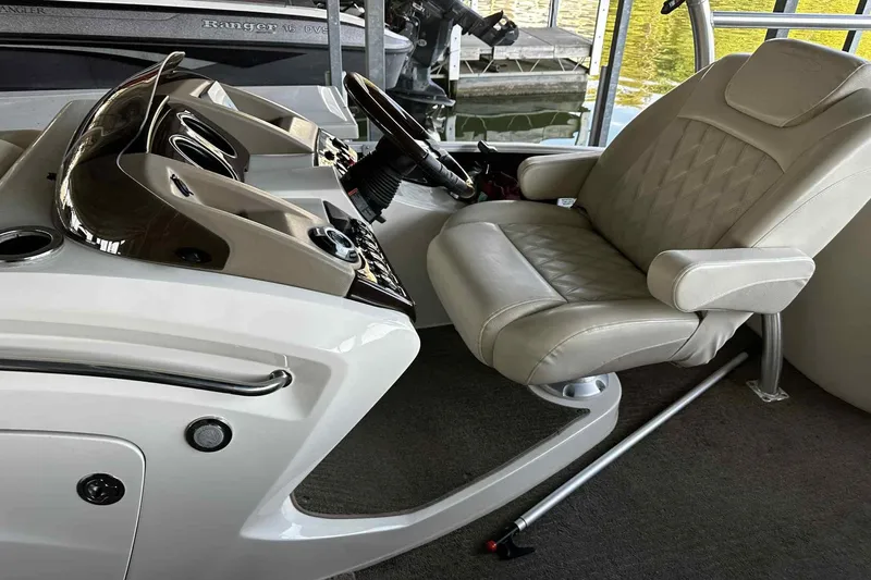 Slide: The Image of Captain's chair and helm of 2014 Bennington 2875 QCW I/O boat, featuring sleek design. - 15