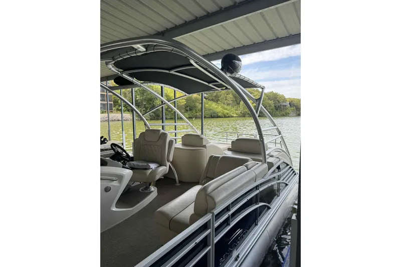 Slide: The Image of 2014 Bennington 2875 QCW I/O pontoon boat docked, featuring spacious seating and sleek design. - 18