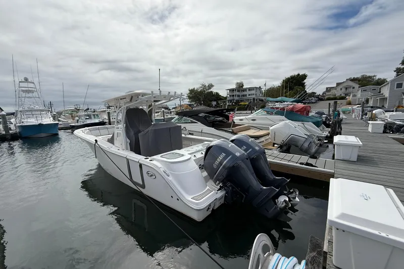 Slide: The Image of 2021 Sea Fox 288 Commander boat docked at a marina with twin Yamaha engines. - 1