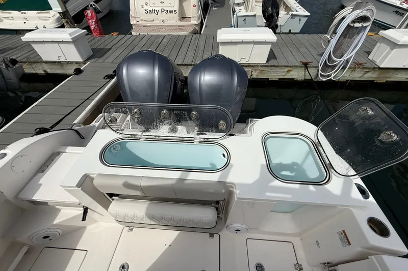 Slide: The Image of 2021 Sea Fox 288 Commander boat with dual engines and open storage compartments at dock. - 10