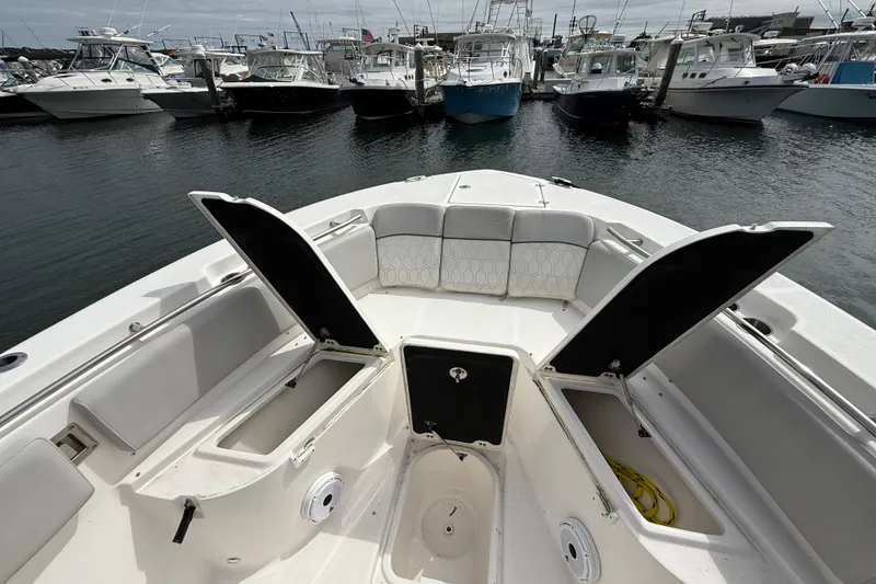 Slide: The Image of 2021 Sea Fox 288 Commander boat with open storage compartments, docked among other boats. - 35