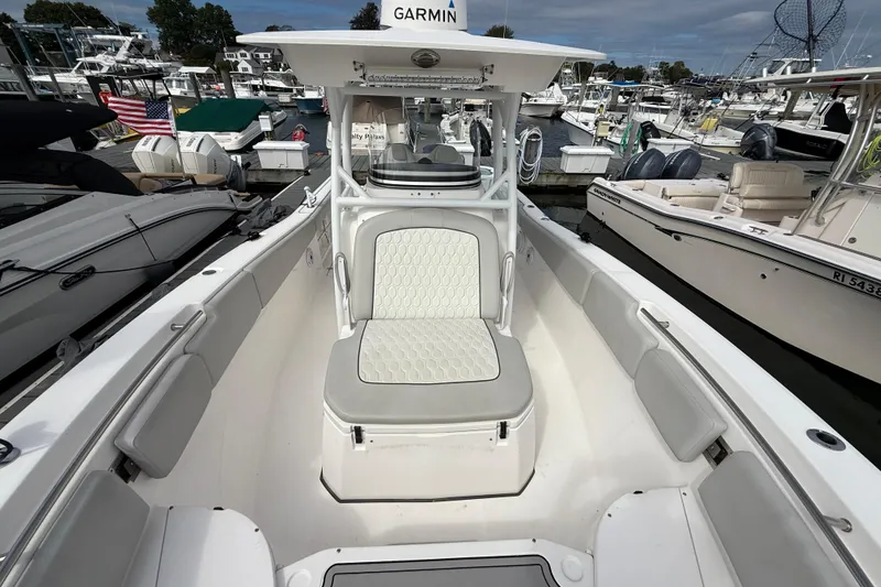Slide: The Image of 2021 Sea Fox 288 Commander boat interior at marina, featuring cushioned seating and Garmin equipment. - 37