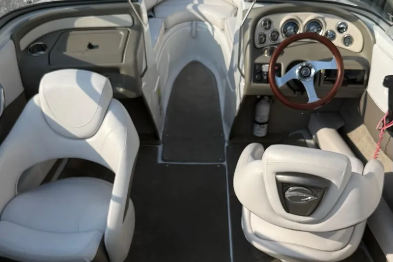 Slide: The Image of Interior of a 2012 195 SS boat featuring white seats and a wooden steering wheel. - 4