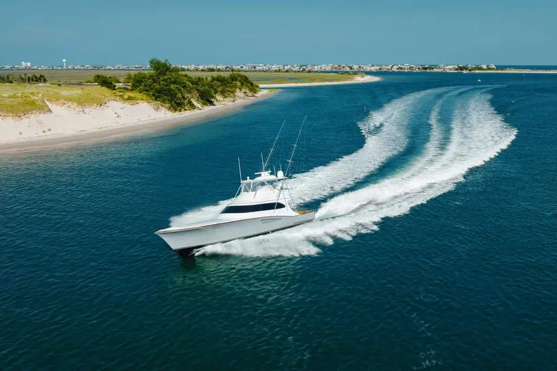 Slide: The Image of 2025 Weaver Sportfish boat cruising in clear blue waters near a sandy coastline. - 3