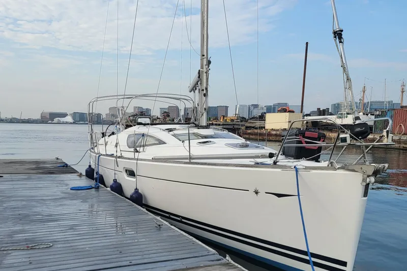 Slide: The Image of 2008 Jeanneau Sun Odyssey 42 DS sailboat docked at a marina with city skyline. - 0