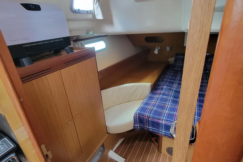Slide: The Image of Interior cabin of 2008 Jeanneau Sun Odyssey 42 DS with plaid bedding and wood finish. - 12