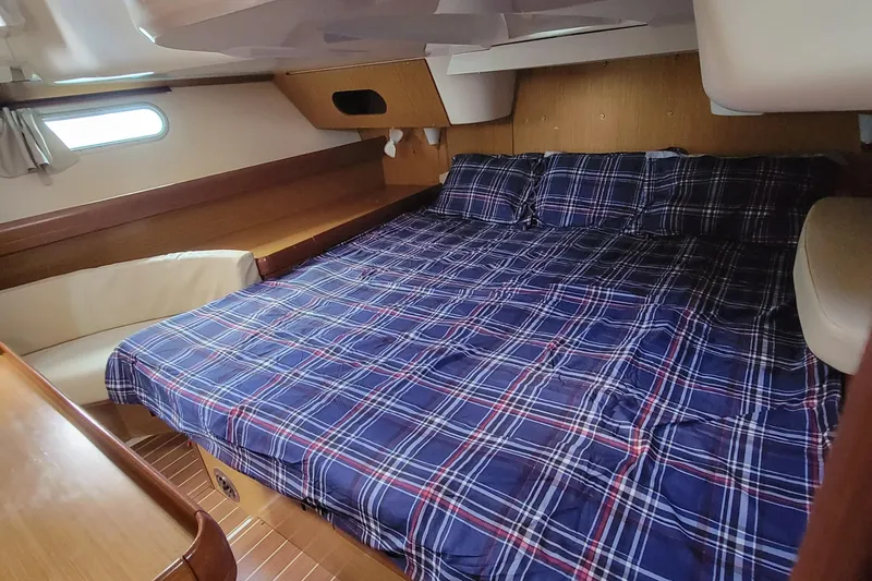 Slide: The Image of Cozy cabin interior of 2008 Jeanneau Sun Odyssey 42 DS with plaid bedding. - 2
