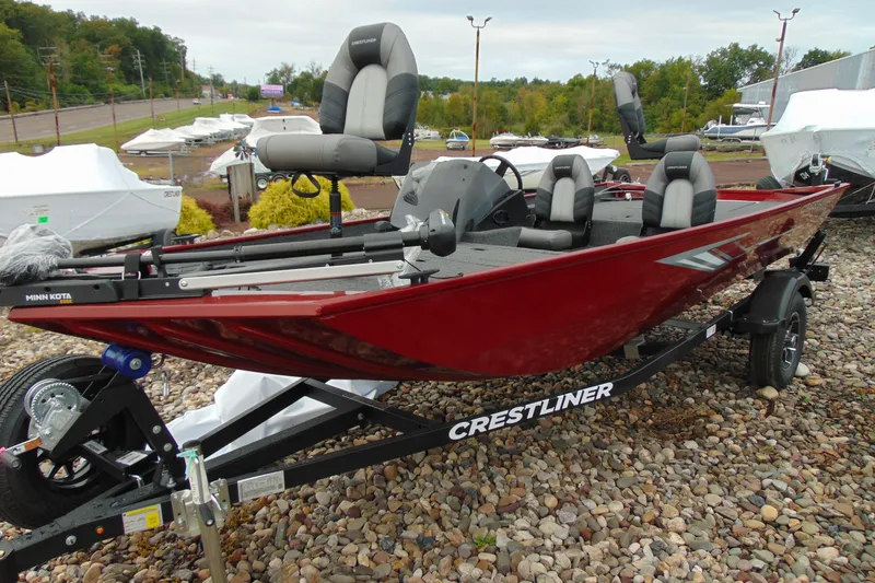The Image of 2026 Crestliner 1700 Storm fishing boat in red on a trailer, parked outdoors. - 1