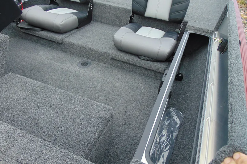 Slide: The Image of 2026 Crestliner 1700 Storm boat interior with gray seating and storage compartment. - 11