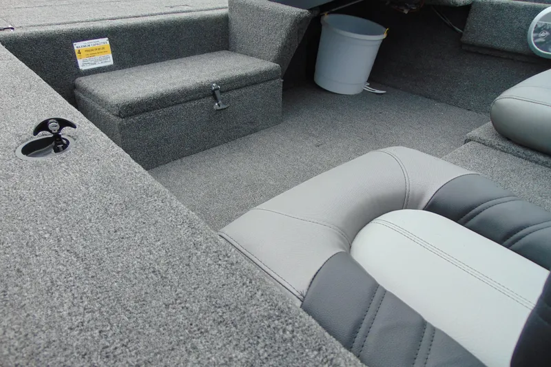 Slide: The Image of 2026 Crestliner 1700 Storm boat interior with gray seating and storage compartments. - 13