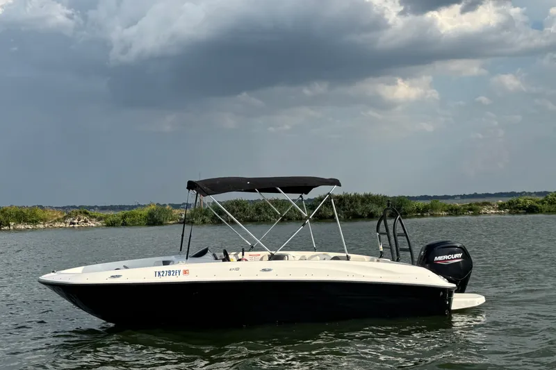 The Image of 2020 Bayliner Element E18 boat on a lake under cloudy skies. - 0