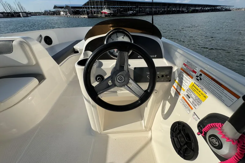 Slide: The Image of 2020 Bayliner Element E18 boat dashboard with steering wheel, docked at marina. - 10