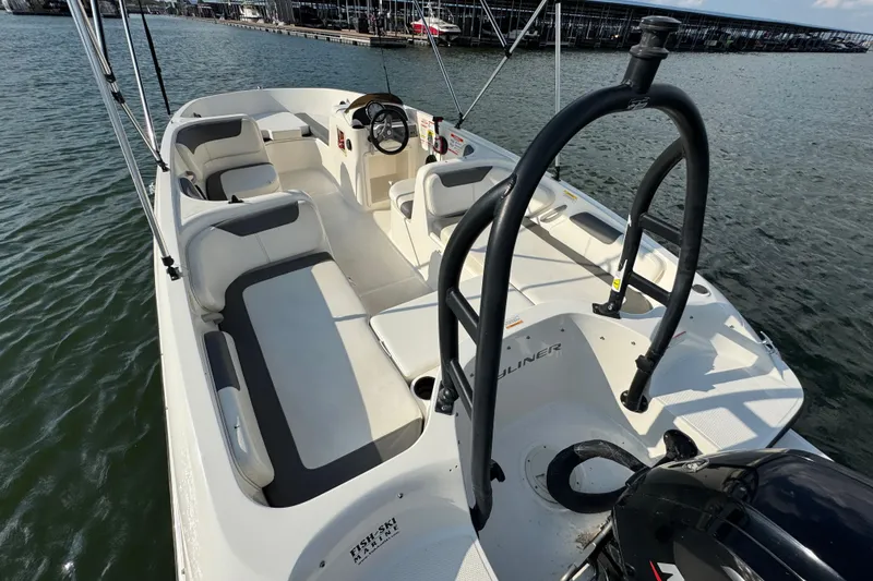 Slide: The Image of 2020 Bayliner Element E18 boat interior with seating and steering wheel on the water. - 14