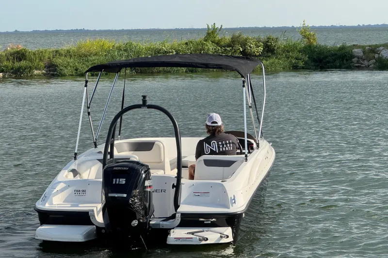 Slide: The Image of 2020 Bayliner Element E18 boat on water with canopy and Mercury engine. - 4