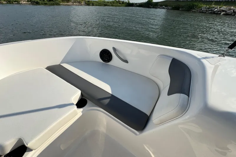 Slide: The Image of 2020 Bayliner Element E18 boat interior with cushioned seating by the water. - 7