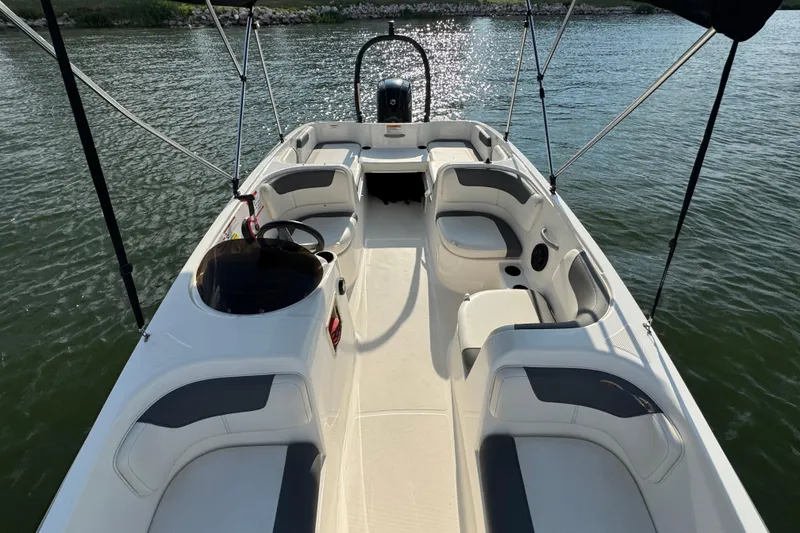 Slide: The Image of 2020 Bayliner Element E18 boat interior with seating, on calm water. - 8