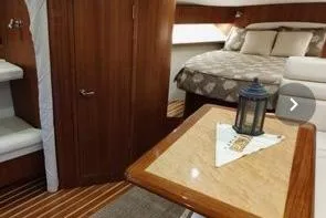 Slide: The Image of 2006 Tiara Yachts 3800 Open interior with cozy bedroom and elegant wood finishes. - 33