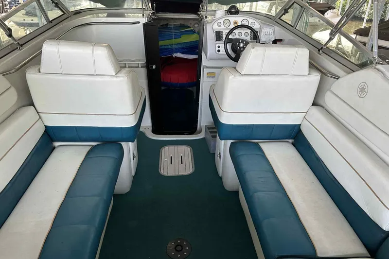 Slide: The Image of Interior of a 1995 Genesis Boats 2505, featuring white and blue seating. - 14