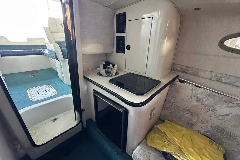 Slide: The Image of Interior of a 1995 Genesis Boats 2505, featuring a compact kitchenette and seating area. - 4