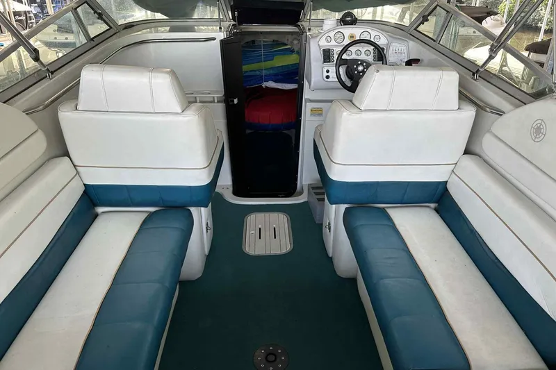 Slide: The Image of Interior of a 1995 Genesis Boats 2505, featuring white and blue seating. - 8