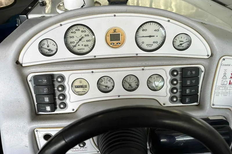Slide: The Image of Dashboard of a 1995 Genesis Boats 2505, featuring gauges and control switches. - 1