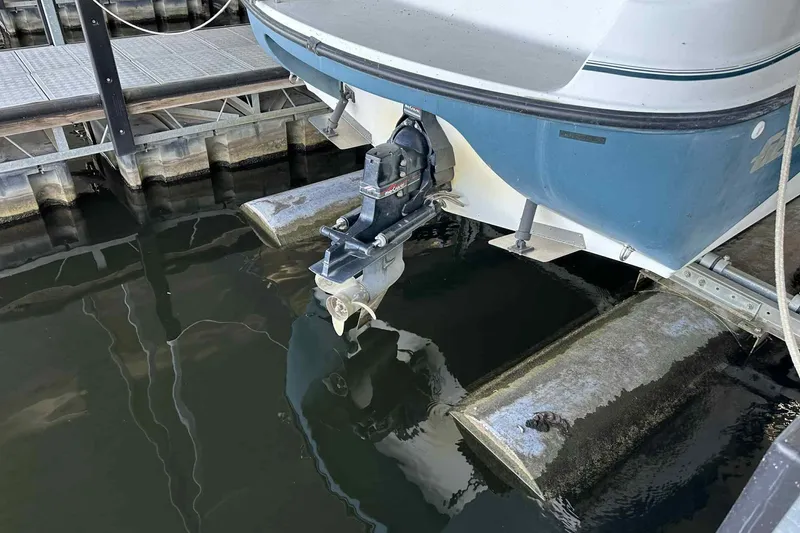 Slide: The Image of 1995 Genesis Boats 2505 with outboard motor docked at marina. - 6