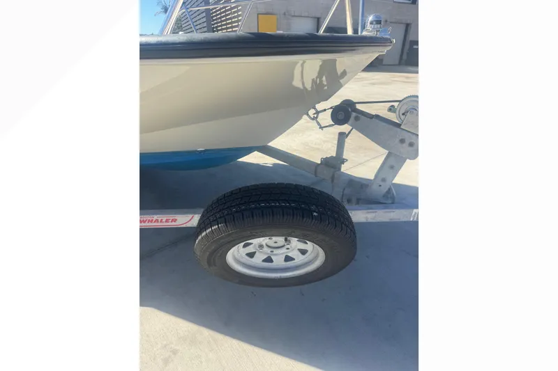 Slide: The Image of 2023 Boston Whaler 150 Montauk boat on trailer, close-up view. - 22
